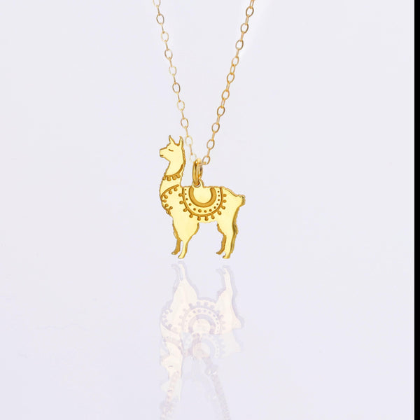 Dainty gold llama pendant with saddle blanket detail on a fine chain