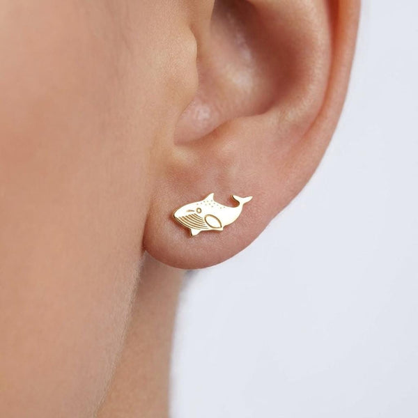 Pair of small gold whale stud earrings shown flat on a white background.