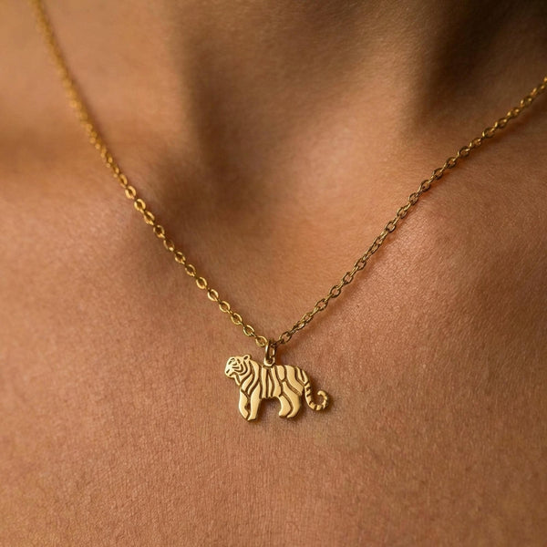 Small gold tiger pendant with cut stripes on a fine cable chain