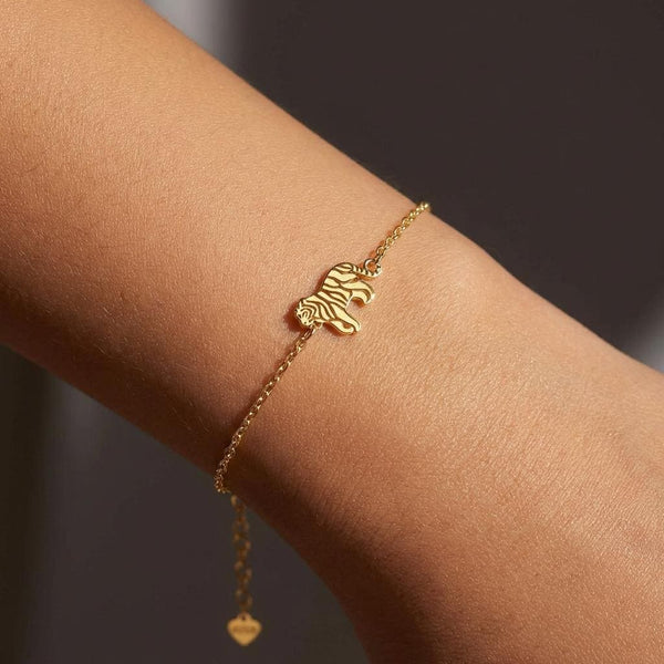 Fine gold chain bracelet with a small striped tiger charm and a lobster clasp