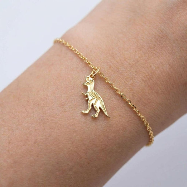 Fine gold chain bracelet with a small T-Rex skull fossil charm