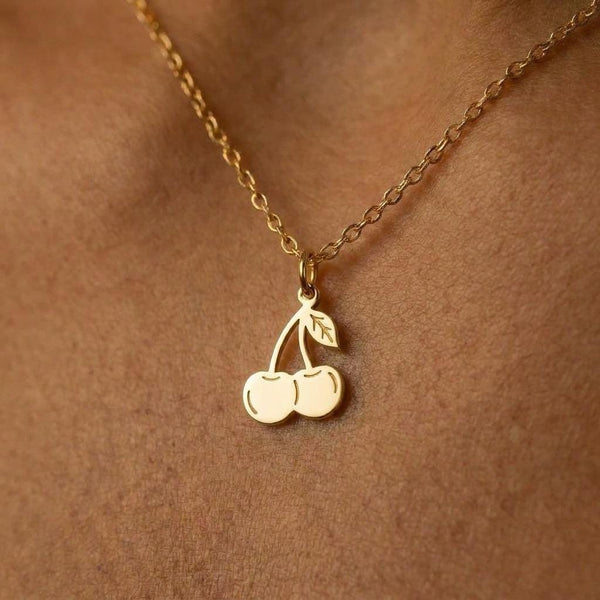 Small gold cherry pair pendant with a curved stem hanging from a fine cable chain
