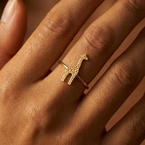 Thin gold ring with a small sculpted giraffe across the top, spots cut into the body