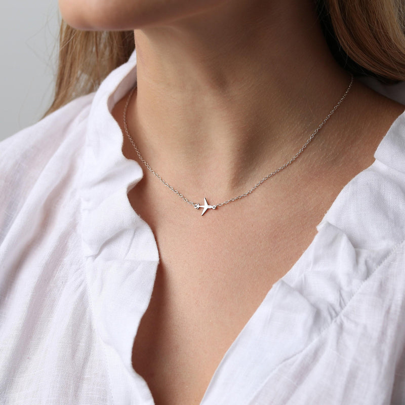 Small gold airplane pendant seen from above on a fine cable chain