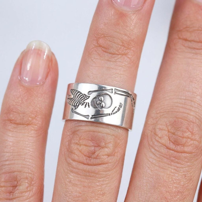 Thin gold ring with a flat skeleton figure along the band (3 of 9)