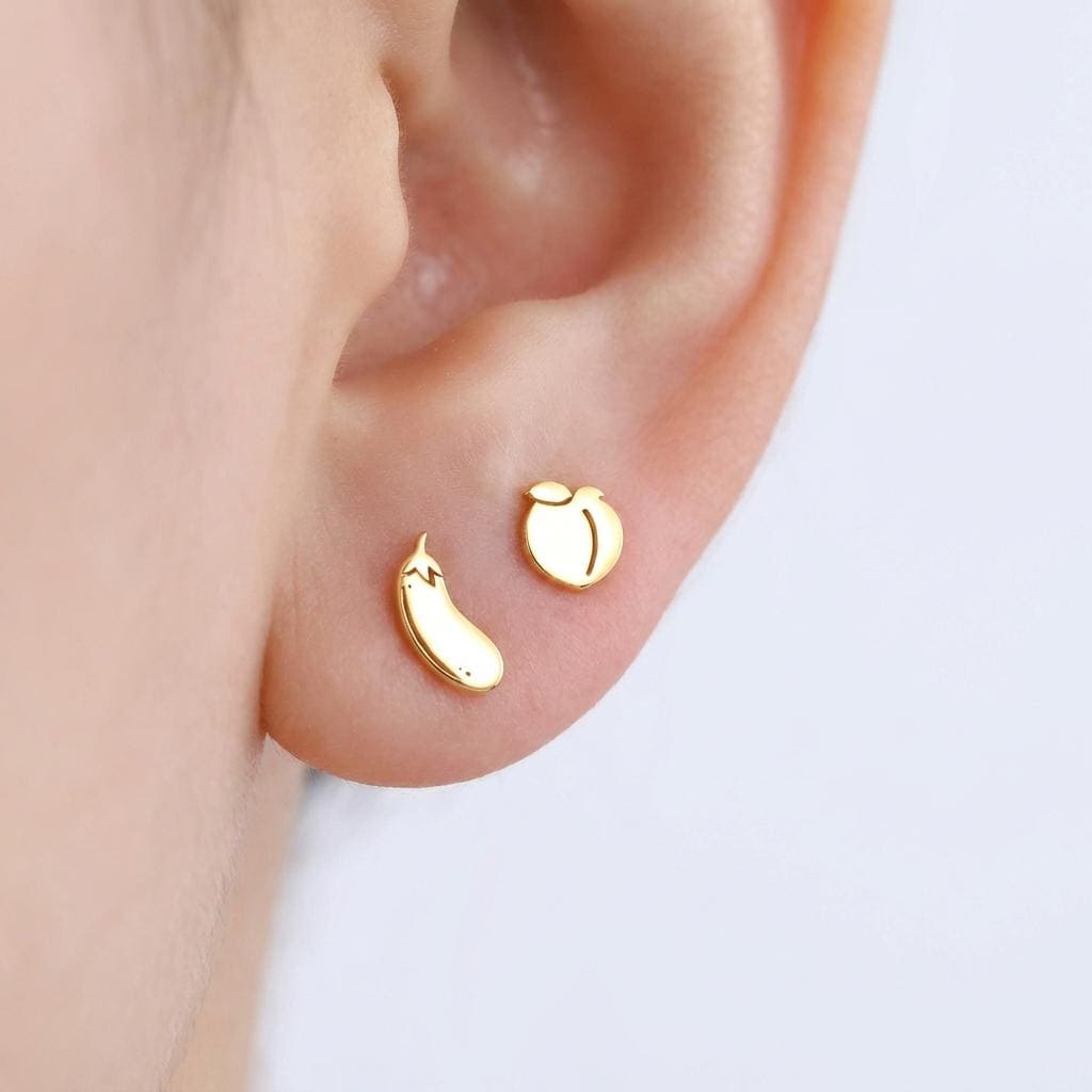 Mismatched pair of tiny gold peach and eggplant emoji stud earrings