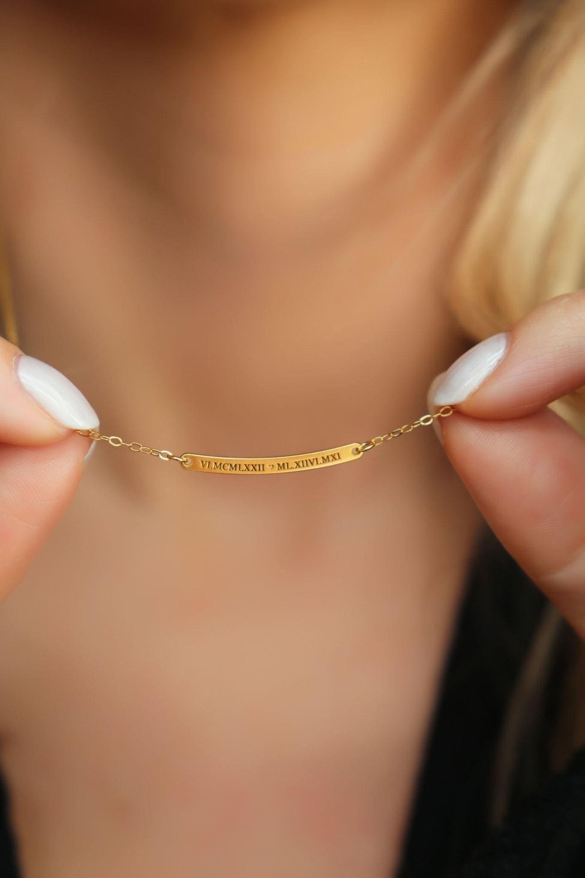 Curved gold bar pendant with Roman numerals across the face on a fine chain.