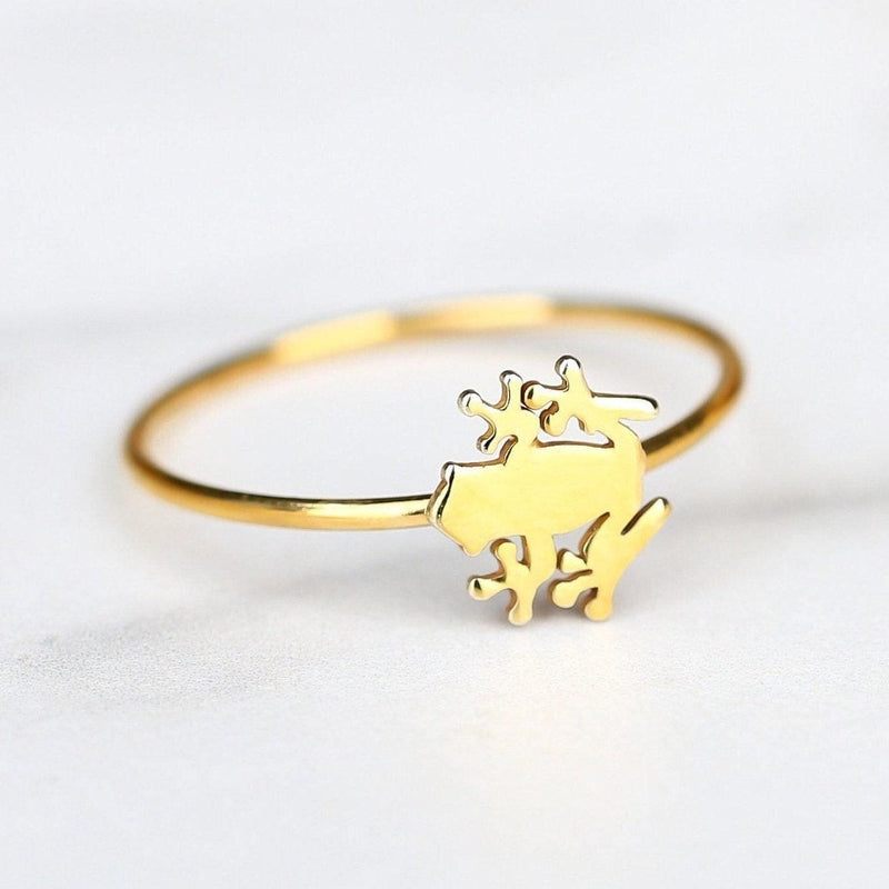 Dainty gold ring with a small crouching frog sitting on a very thin band