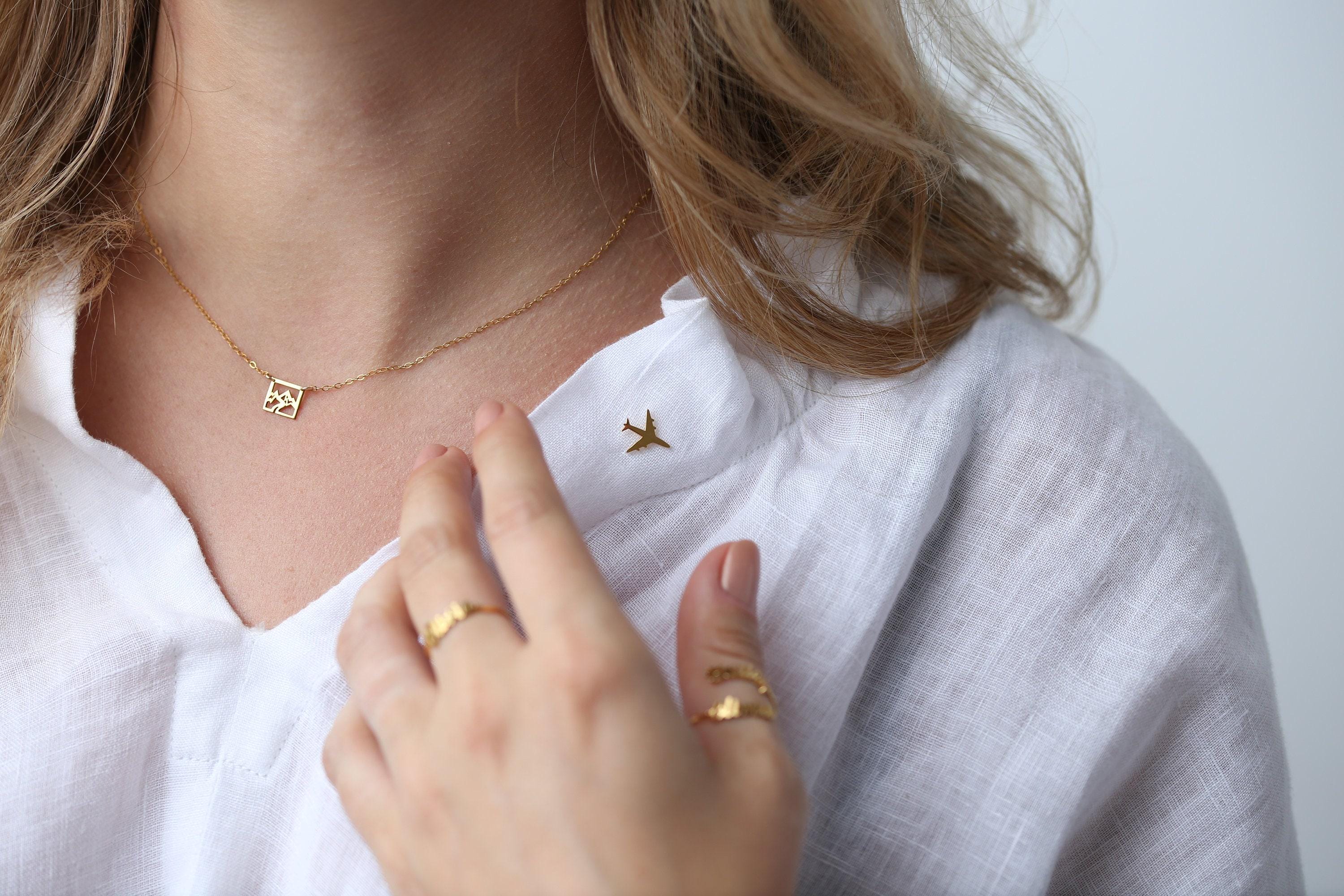 Small gold airplane lapel pin shown at an angle on a white background (2 of 5)