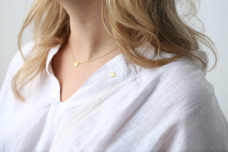Small gold airplane lapel pin shown at an angle on a white background (3 of 5)