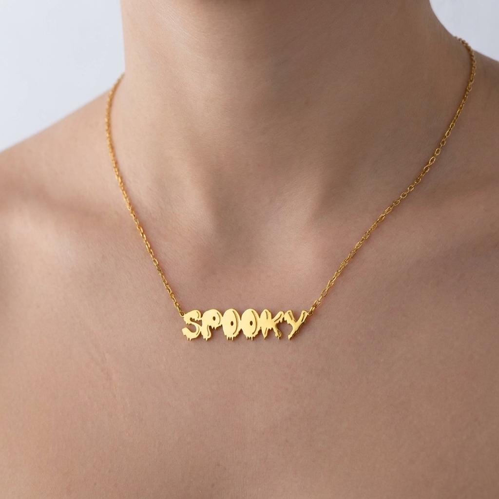 Gold script word pendant reading spooky with connected letters on a fine chain