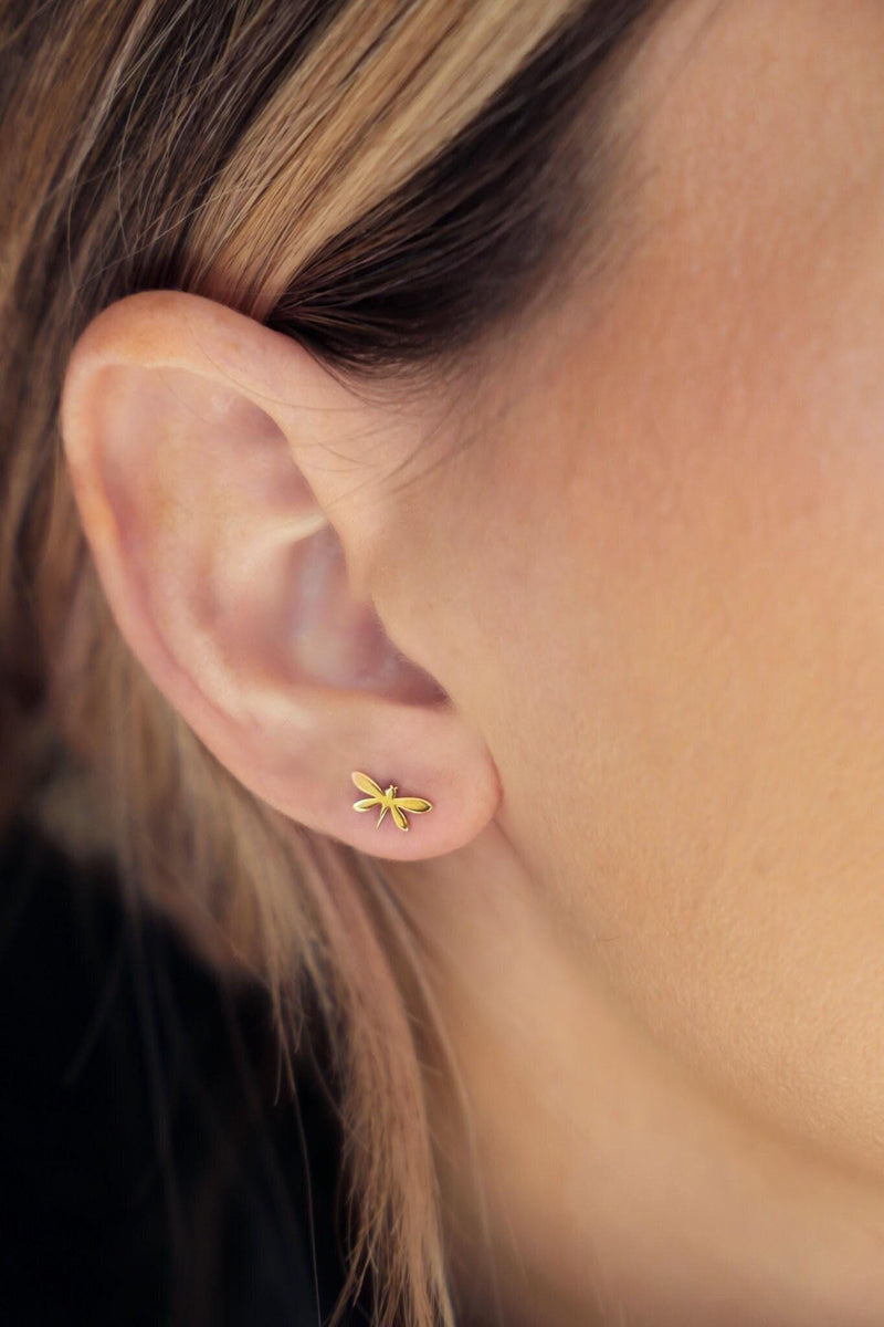 Pair of narrow gold dragonfly stud earrings with four wings, shown front on. (8 of 11)