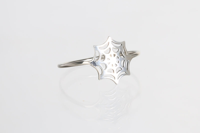 Thin gold ring with a delicate spider web pattern traced around the band