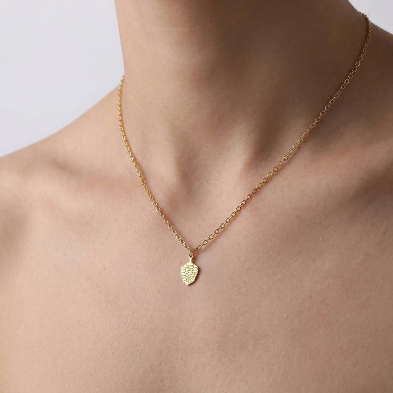 Small gold pinecone pendant with spiraled scales on a fine chain