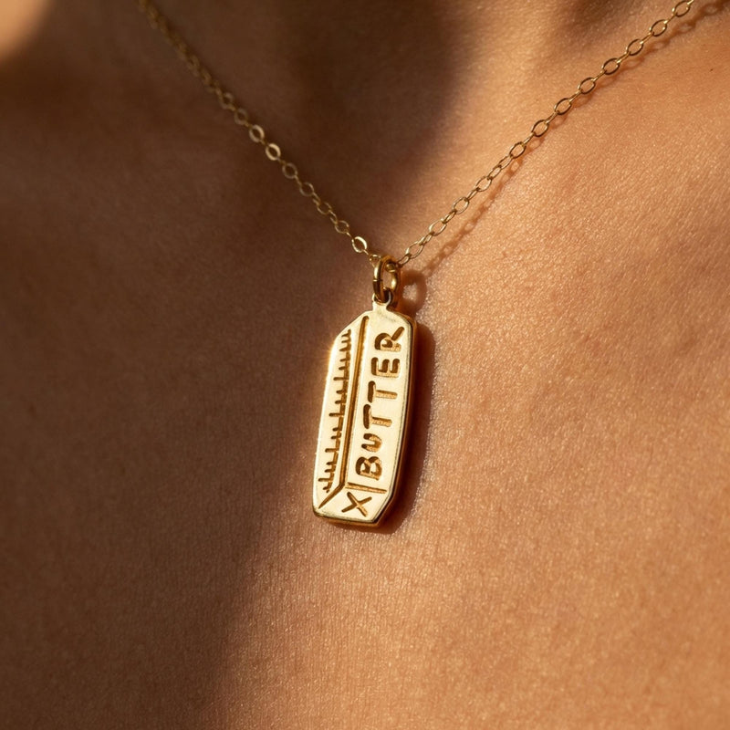 Fine gold chain necklace with a small pendant shaped like a stick of butter (2 of 13)