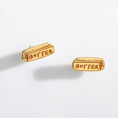Pair of small gold stick of butter stud earrings with wrapper detail
