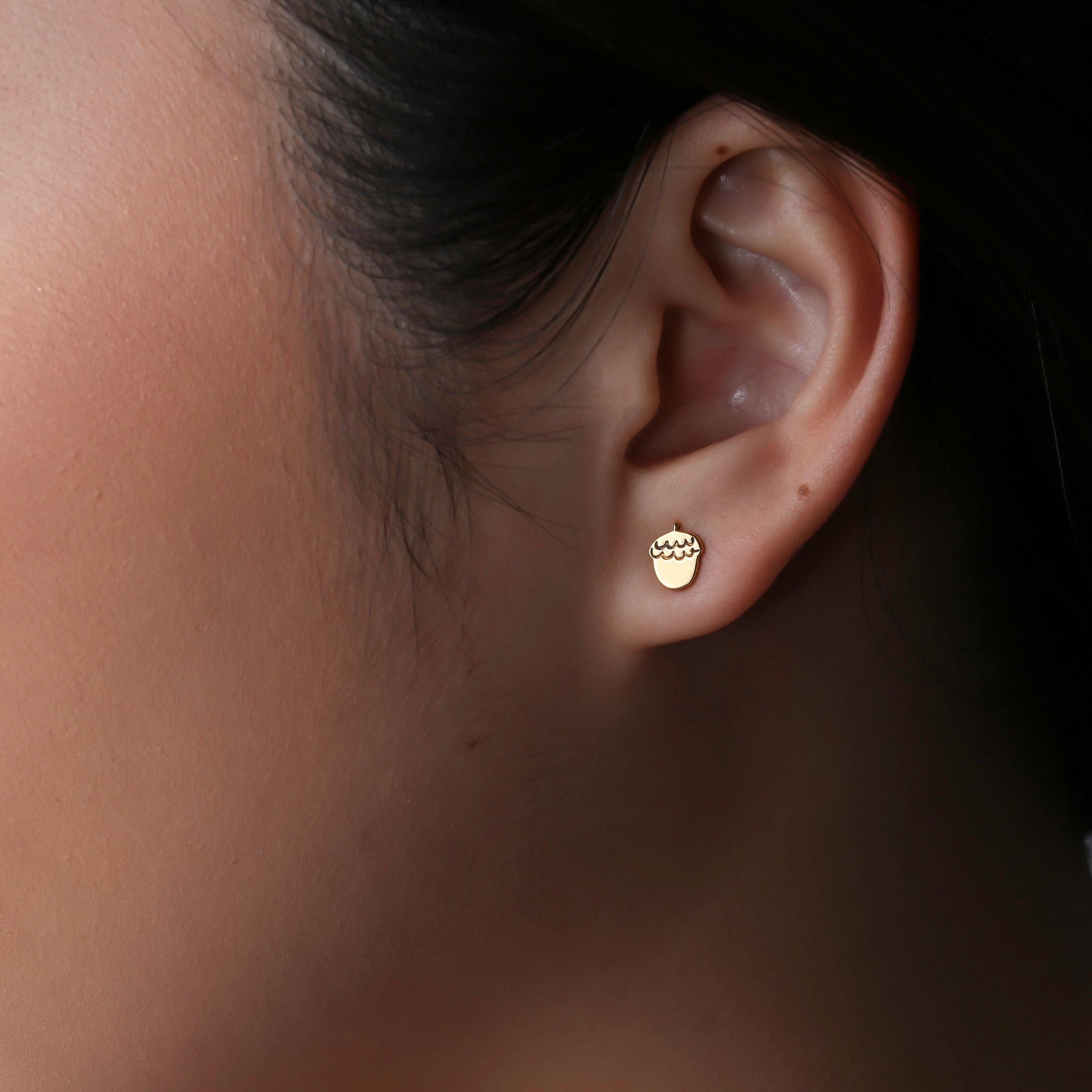 Pair of small gold acorn stud earrings with a textured cap and smooth body (2 of 13)