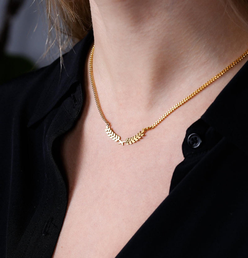 Slim curved gold olive branch pendant with two leaves on a fine chain