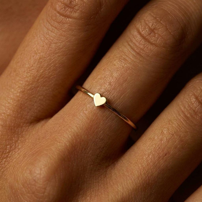 Thin gold stacking ring with a small flat heart on the top of the band