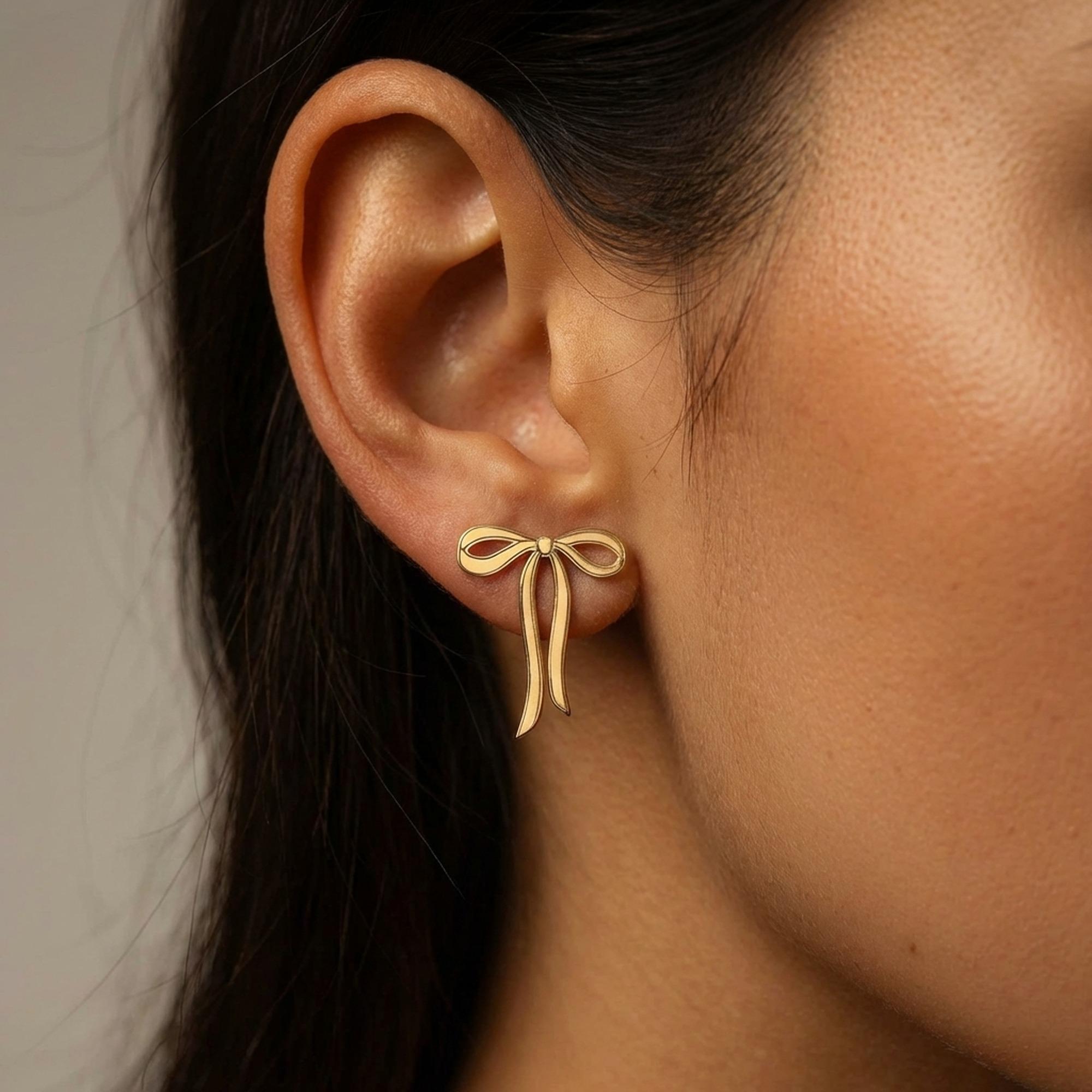 Pair of gold ribbon bow stud earrings shown flat on a white background. (2 of 10)