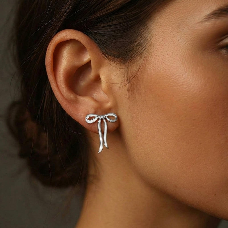 Pair of gold ribbon bow stud earrings shown flat on a white background. (3 of 10)
