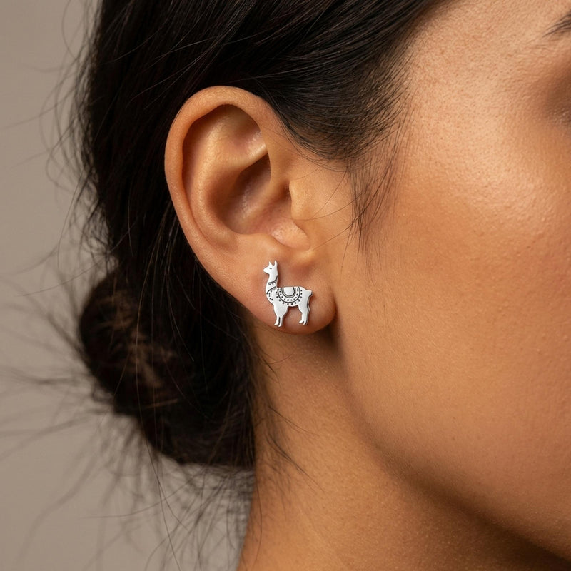 Pair of tiny gold llama stud earrings with tufted heads, shown on white (3 of 12)