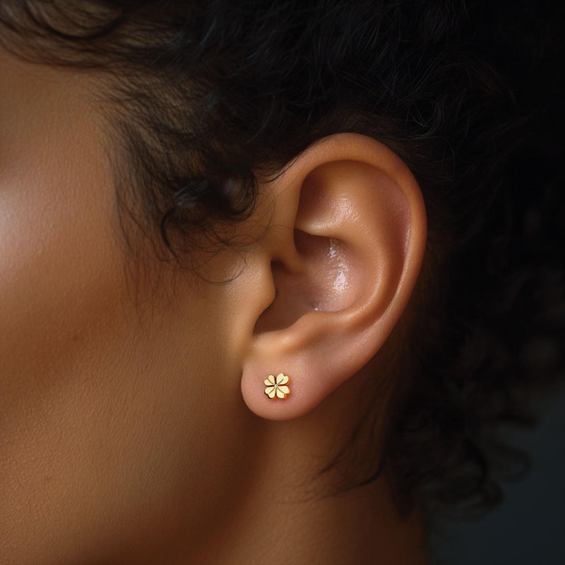 Tiny gold four leaf clover stud earrings shown as a pair on a plain background (4 of 11)