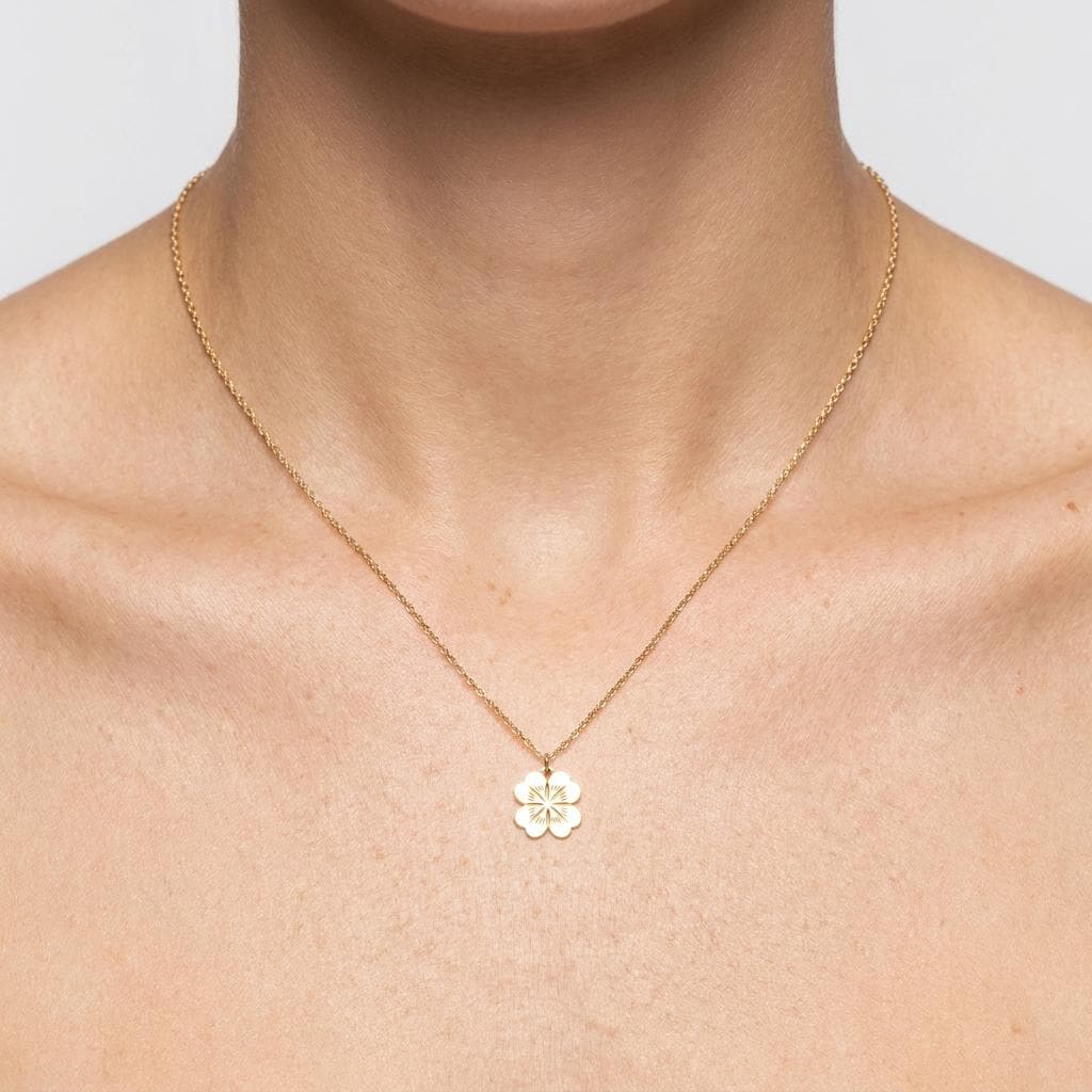 Gold four leaf clover pendant with rounded leaves on a delicate chain necklace