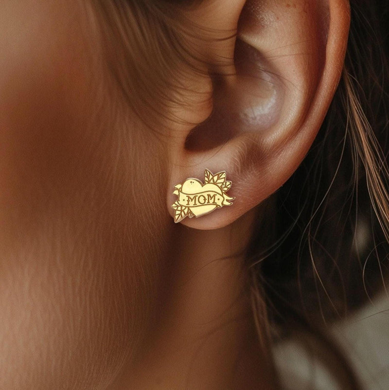 Pair of gold stud earrings shaped like a tattoo heart with a MOM banner (4 of 9)