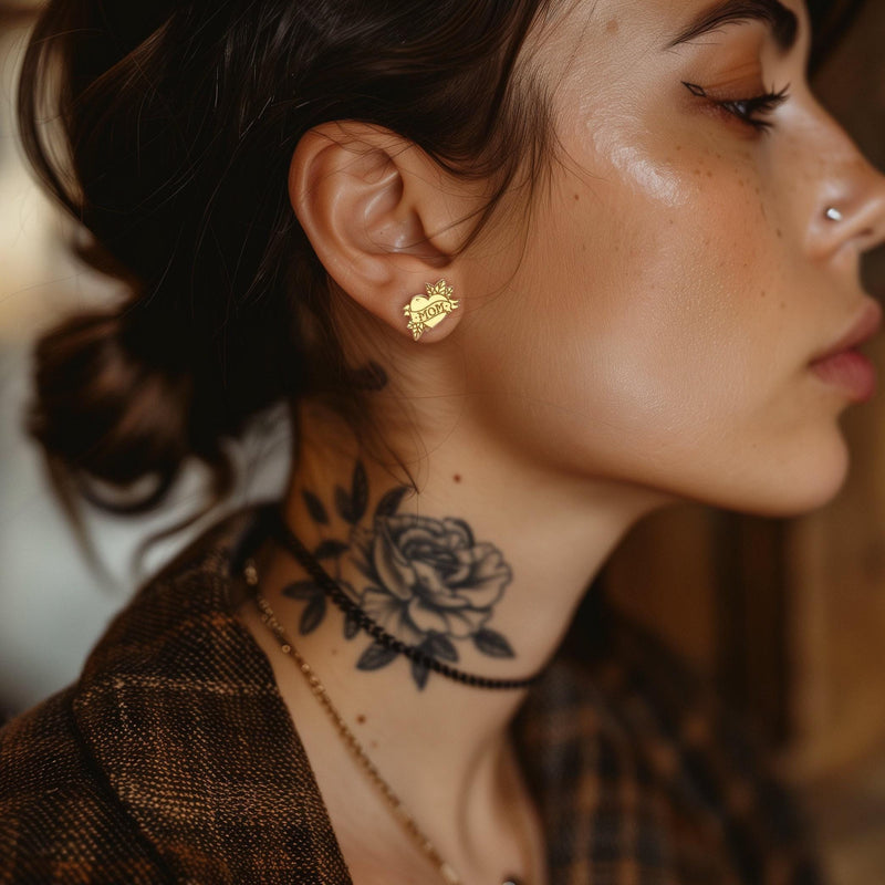 Pair of gold stud earrings shaped like a tattoo heart with a MOM banner (5 of 9)