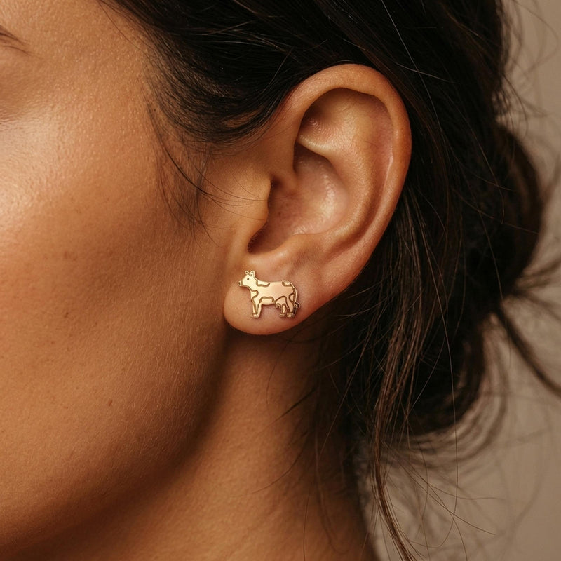 Pair of small highland cow face stud earrings in gold, fringe and ears visible (5 of 9)