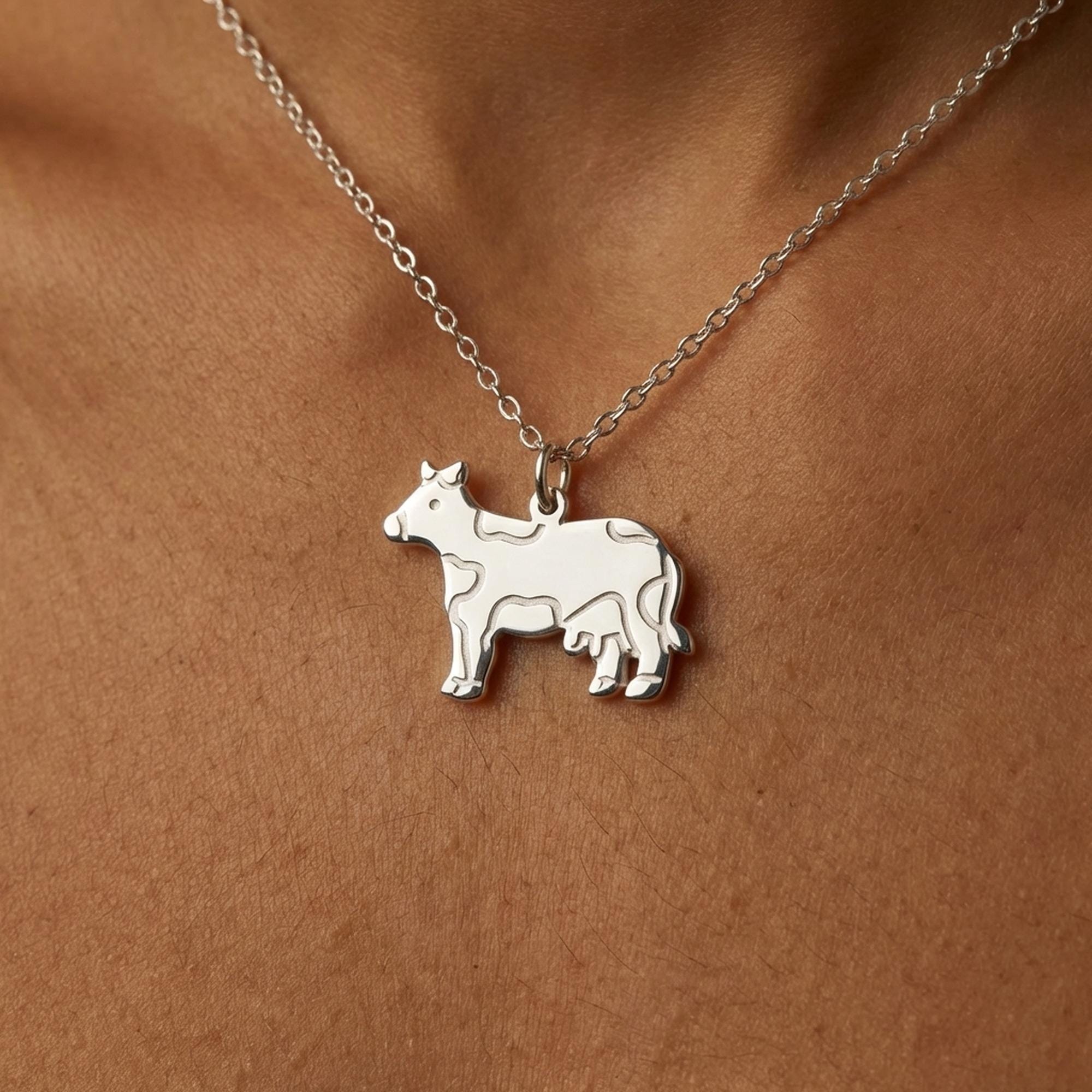 Small silver cow pendant in profile on a fine cable chain, shown on white (2 of 11)