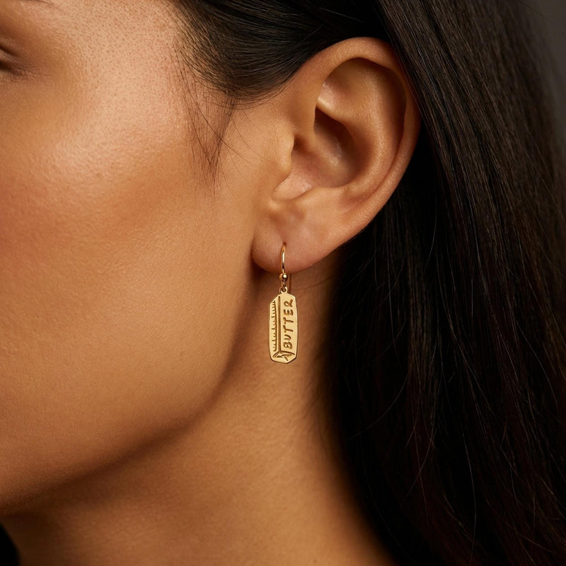 Pair of gold butter stick drop earrings hanging from small posts (10 of 10)