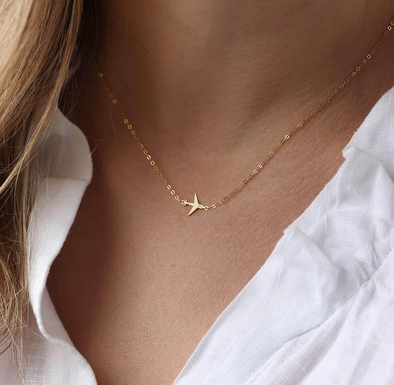 Small gold airplane pendant on a fine cable chain necklace