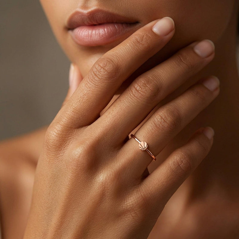 Thin gold ring with a small basketball charm showing seam lines (3 of 10)