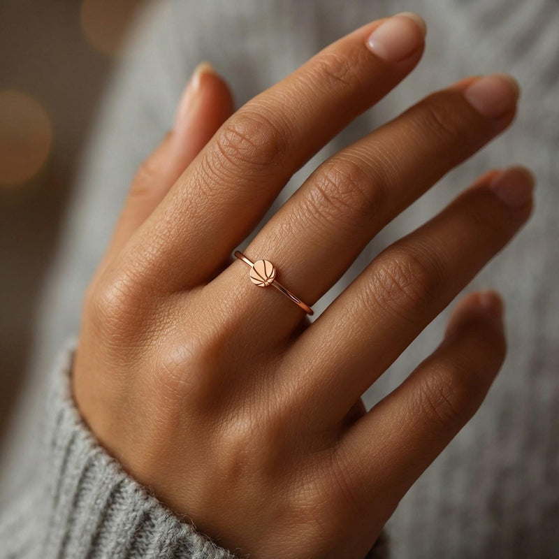 Thin gold ring with a small basketball charm showing seam lines (4 of 10)