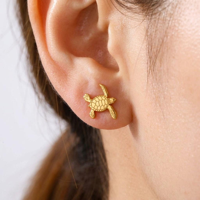 Pair of small turtle stud earrings in gold seen from above with a patterned shell