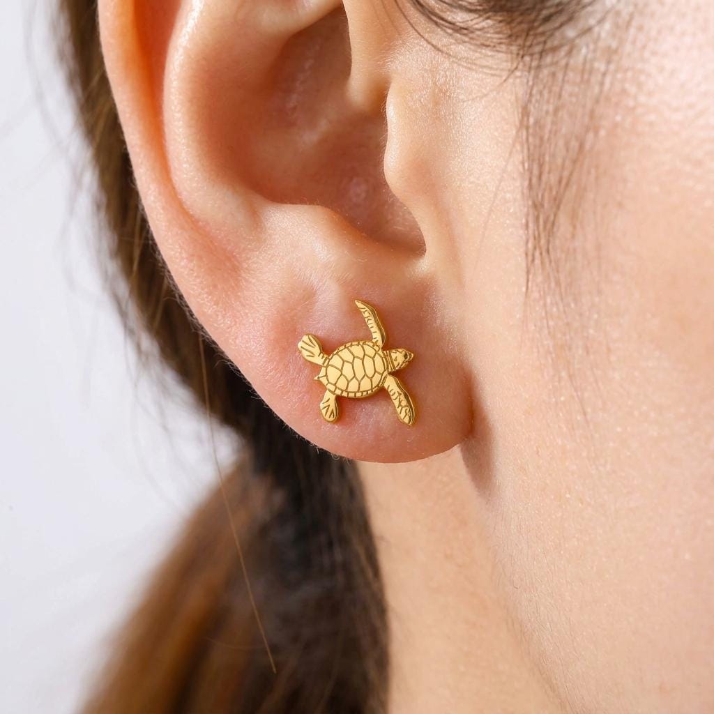 Pair of small turtle stud earrings in gold seen from above with a patterned shell