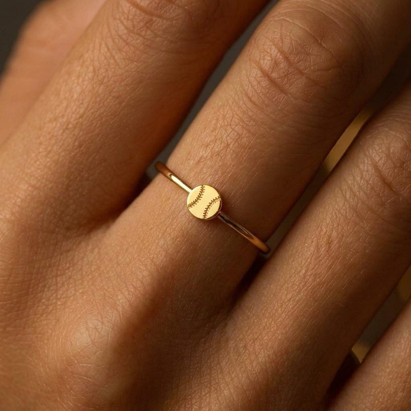 Thin gold stacking ring with a tiny baseball on the top of the band