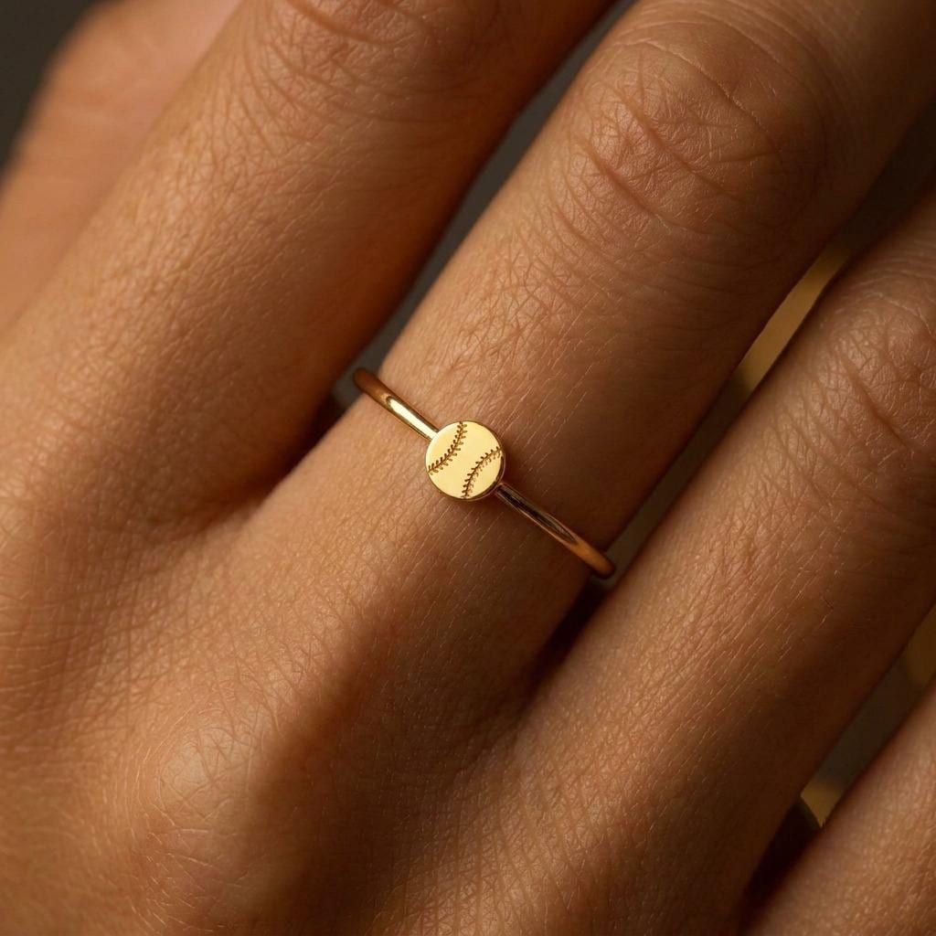 Thin gold stacking ring with a tiny baseball on the top of the band