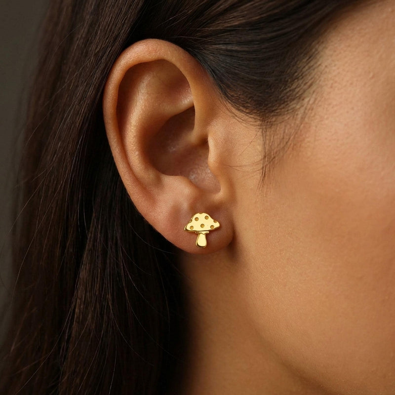 Pair of tiny gold mushroom stud earrings with spotted caps on white (10 of 10)