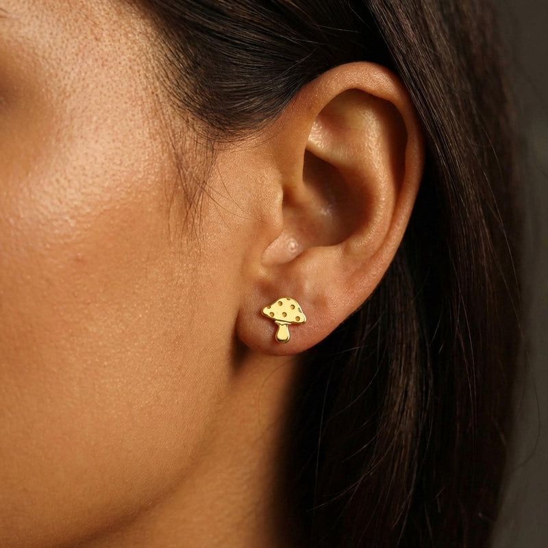 Pair of tiny gold mushroom stud earrings with spotted caps on white (3 of 10)