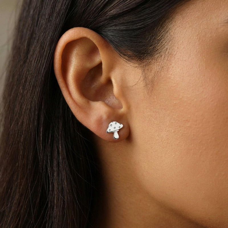 Pair of tiny gold mushroom stud earrings with spotted caps on white (4 of 10)