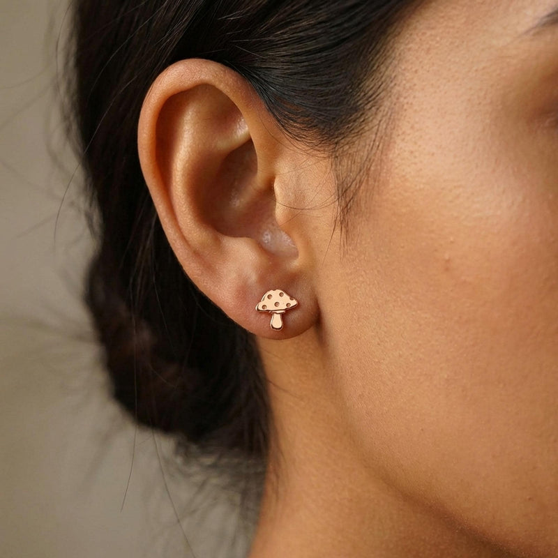 Pair of tiny gold mushroom stud earrings with spotted caps on white (5 of 10)