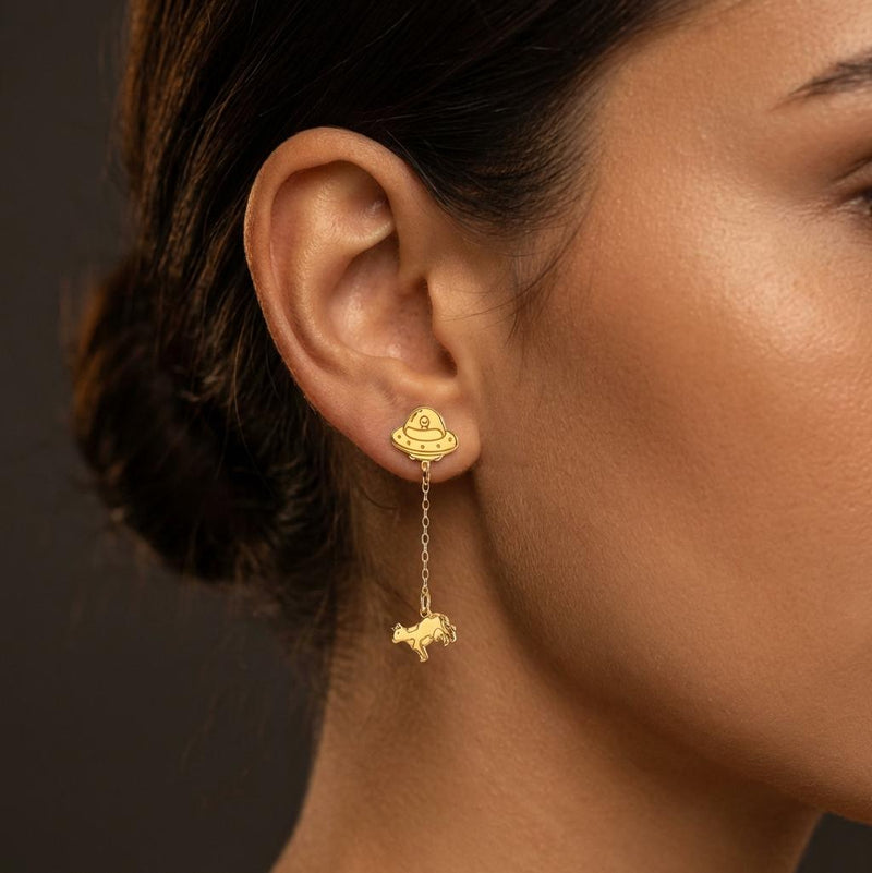 Tiny gold stud earrings showing a UFO beaming up a small cow (5 of 13)