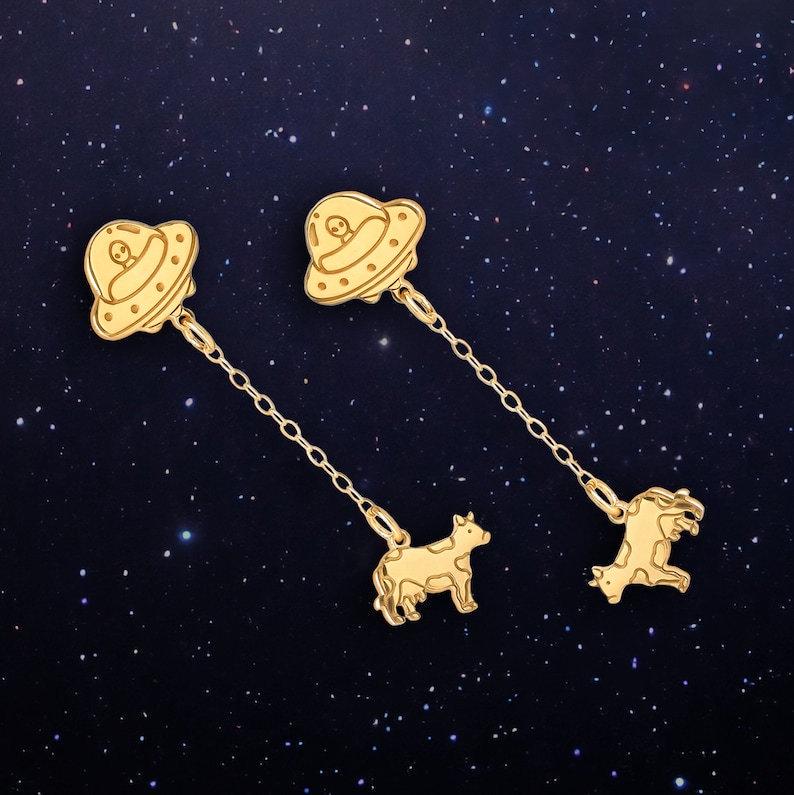 Tiny gold stud earrings showing a UFO beaming up a small cow (6 of 13)