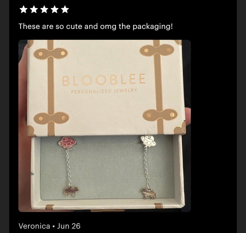 Tiny gold stud earrings showing a UFO beaming up a small cow (9 of 13)