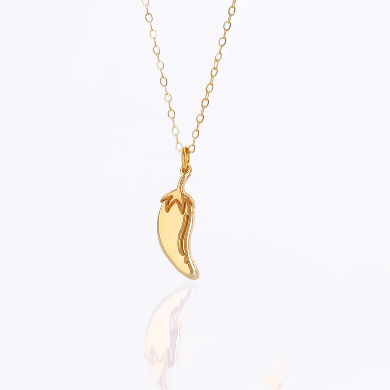 Fine gold necklace with a small curved chili pepper pendant