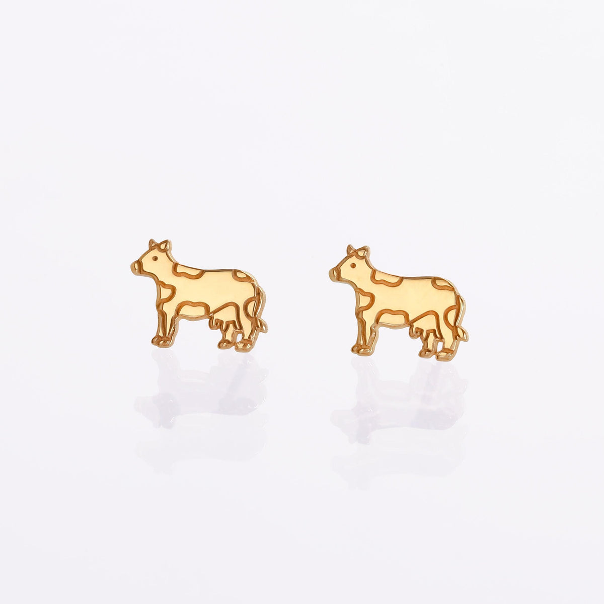 Pair of small rose gold cow face stud earrings with patch markings