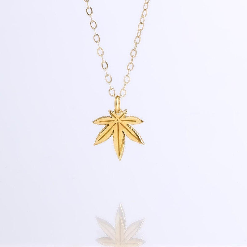 Small gold seven point marijuana leaf pendant on a fine cable chain necklace